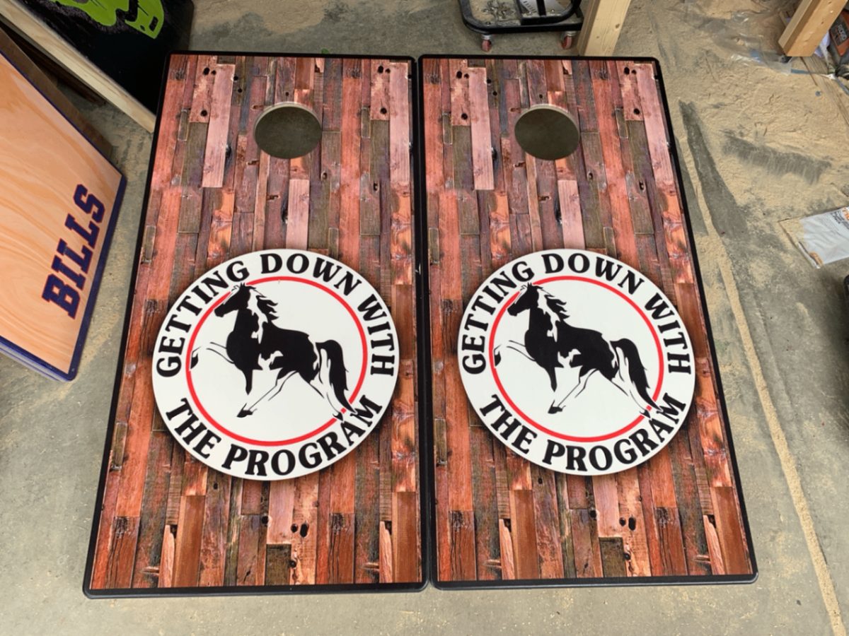 Pair of custom printed cornhole boards with a wood-plank finish and horse logo